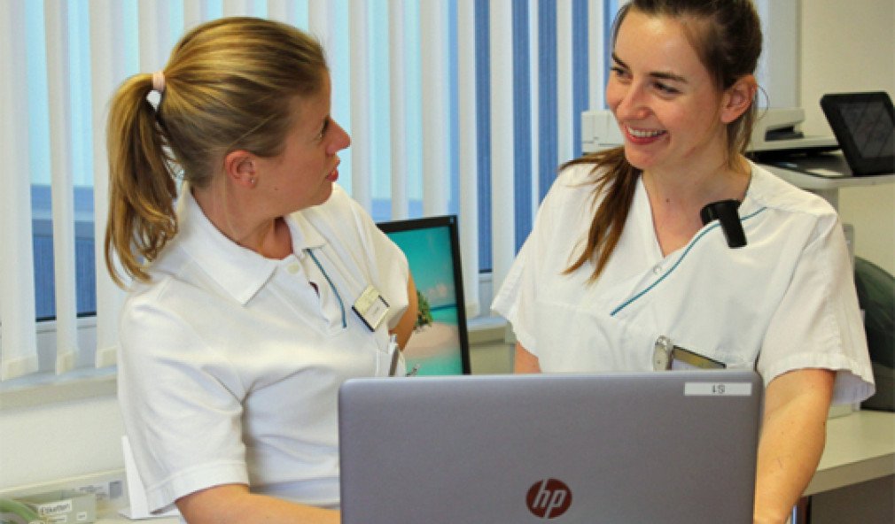 klinische Fachspezialistin mit Pflegefachperson im Gespräch