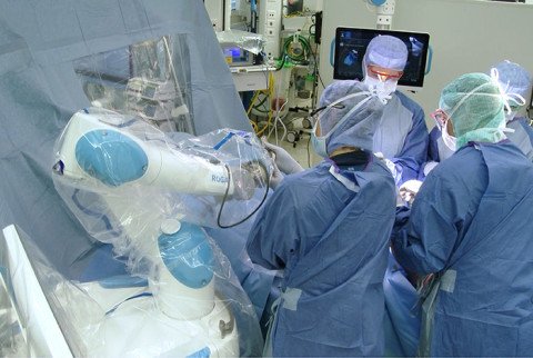 OP-Szene mit OP-Roboter Rosa und Chirugen