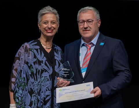 Mario Bizzini (rechts) erhält den World Physiotherapy International Service Award 2023 für Forschung von Emma Stokes (links)